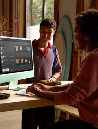 Two people in a well-lit room, viewing products on the iMac nano-texture glass display